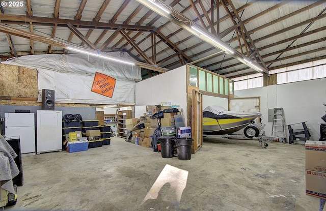 garage featuring metal wall and freestanding refrigerator