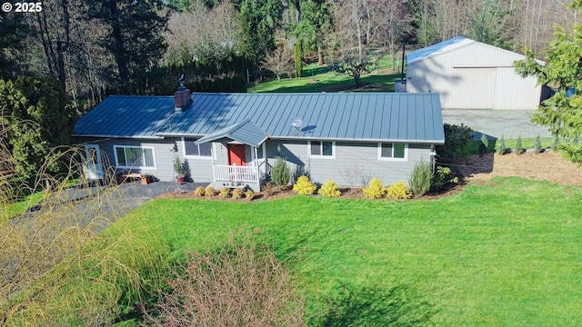 ranch-style house featuring a chimney, a front yard, a standing seam roof, and metal roof