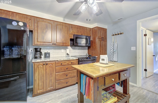 kitchen with visible vents, tasteful backsplash, stainless steel appliances, light wood-style floors, and light countertops