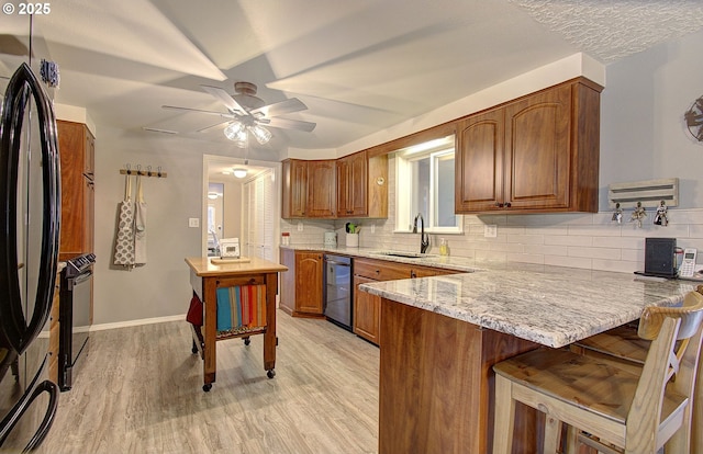 kitchen featuring a sink, fridge, light wood-style floors, a peninsula, and range