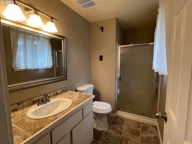 bathroom with vanity, toilet, a shower with shower curtain, and a textured ceiling