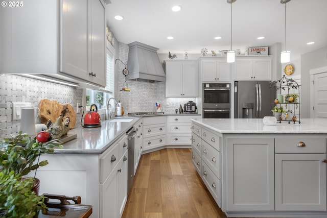 3461 Sterling Woods Dr, Eugene, OR 97408 - kitchen featuring custom range hood, appliances with stainless steel finishes, backsplash, gray cabinetry, and light wood-type flooring