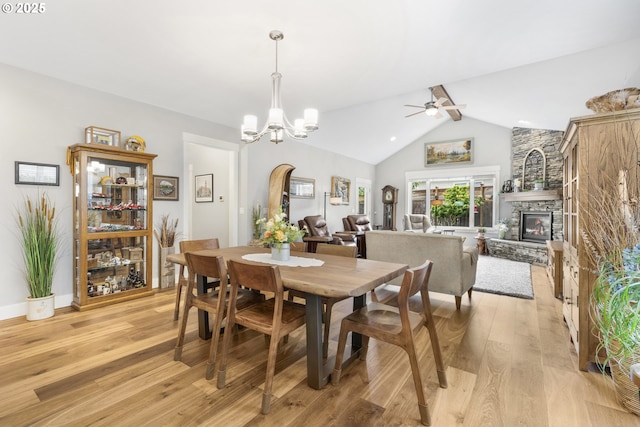 3461 Sterling Woods Dr, Eugene, OR 97408 - dining area featuring light wood-style flooring, ceiling fan, a chandelier, and a stone fireplace