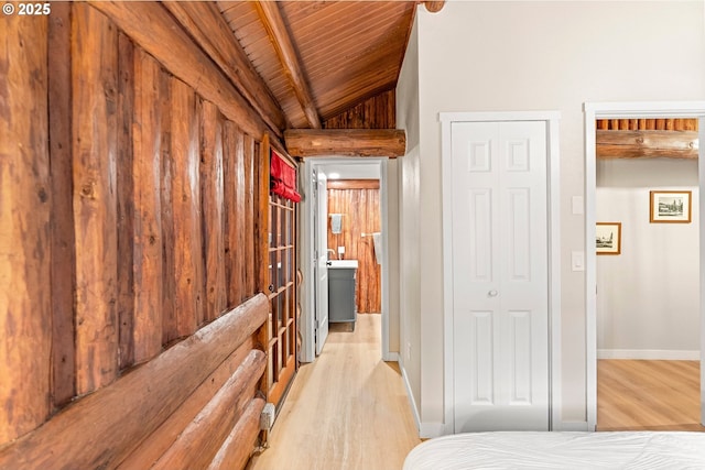 bedroom with vaulted ceiling with beams, wood ceiling, and light hardwood / wood-style flooring