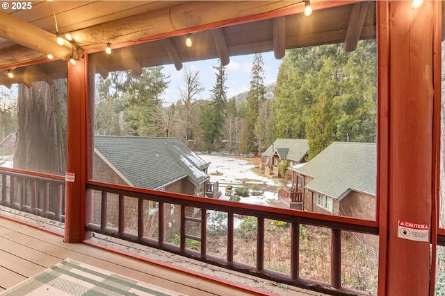 sunroom / solarium featuring beam ceiling