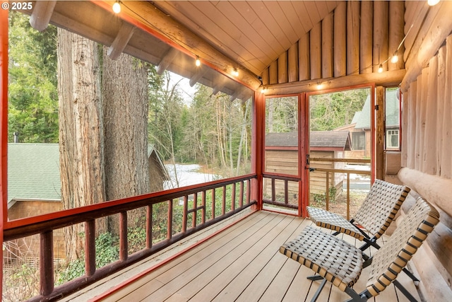 unfurnished sunroom featuring lofted ceiling, wooden ceiling, and a water view