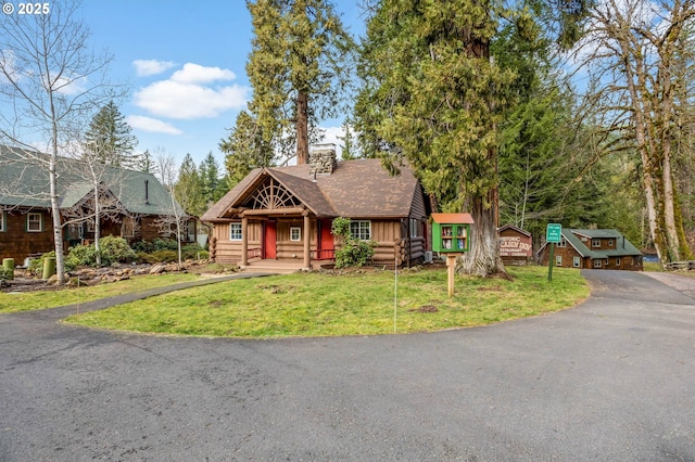 cabin featuring a front lawn