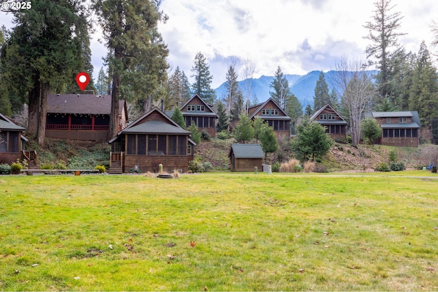 view of yard with a mountain view and a sunroom