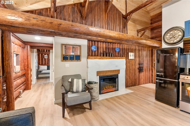 living area with light wood-type flooring, rustic walls, and high vaulted ceiling