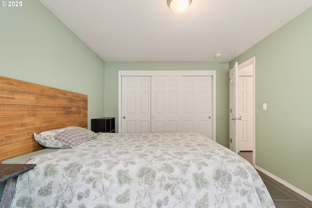 bedroom with baseboards, a closet, and a textured ceiling