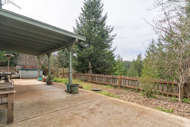 view of patio with fence private yard and a hot tub