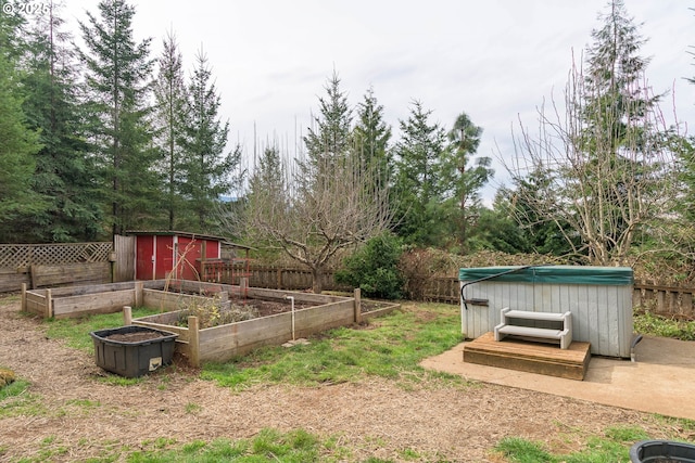 view of yard with a storage shed, an outbuilding, a vegetable garden, and fence