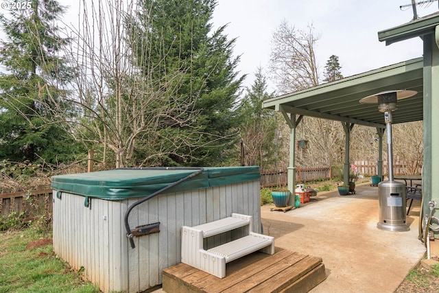 view of patio / terrace featuring a hot tub and fence