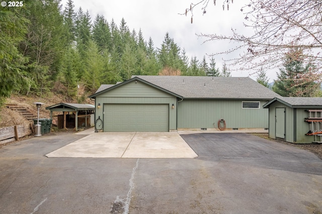 view of front facade with an attached garage, fence, a storage shed, crawl space, and driveway