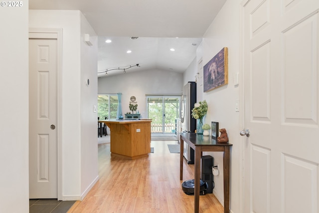 corridor featuring recessed lighting, light wood-type flooring, lofted ceiling, and baseboards