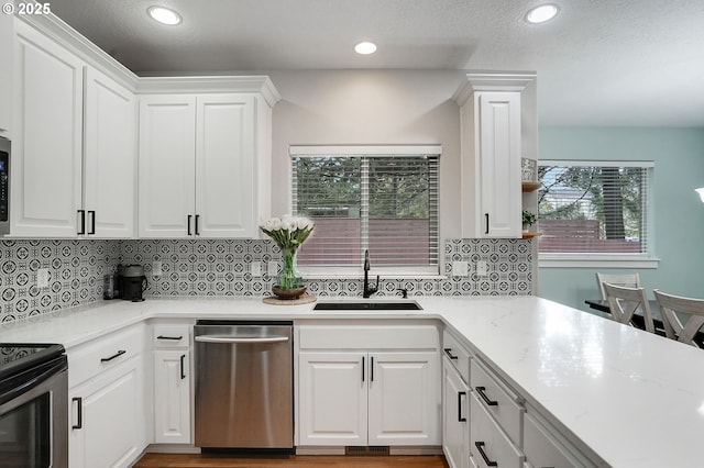 kitchen featuring a sink, white cabinets, appliances with stainless steel finishes, and decorative backsplash