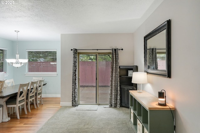 interior space featuring baseboards, an inviting chandelier, wood finished floors, and a textured ceiling