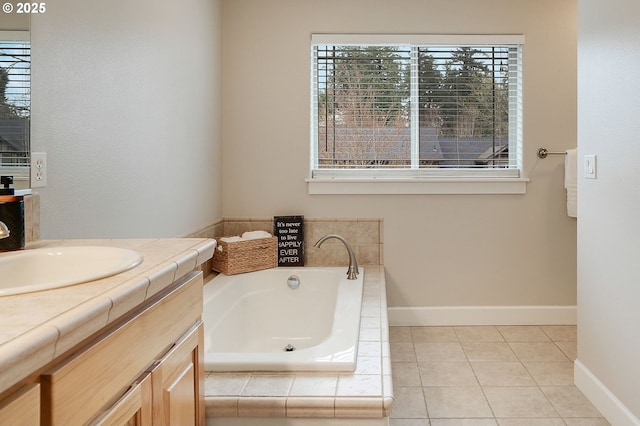 bathroom with tile patterned floors, vanity, baseboards, and a garden tub