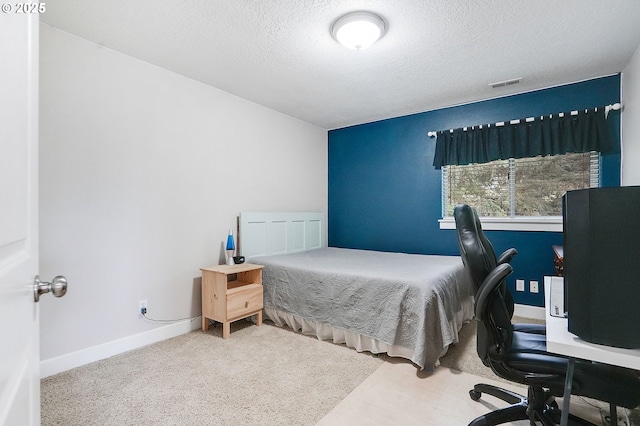 bedroom featuring visible vents, baseboards, carpet flooring, and a textured ceiling
