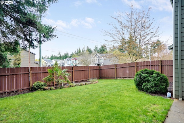 view of yard featuring a fenced backyard and a residential view