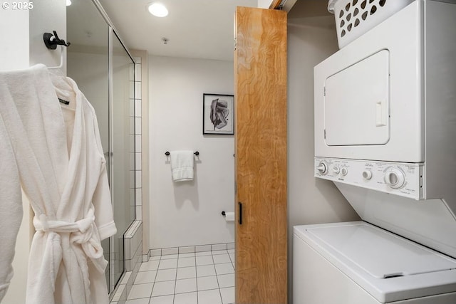 clothes washing area featuring stacked washing maching and dryer, light tile patterned floors, and laundry area