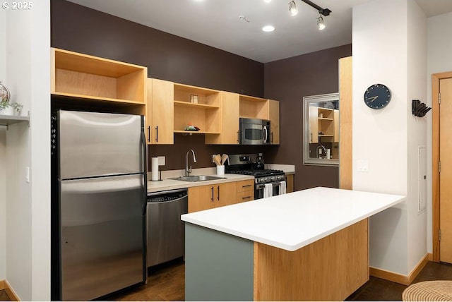 kitchen featuring dark wood finished floors, stainless steel appliances, light countertops, open shelves, and a sink