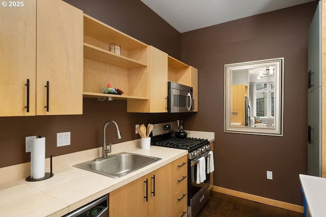 kitchen featuring open shelves, stainless steel appliances, light brown cabinetry, a sink, and baseboards