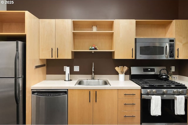 kitchen with light brown cabinets, a sink, light countertops, appliances with stainless steel finishes, and open shelves