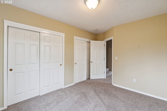 15745 SE Bybee Dr, Portland, OR 97236 - unfurnished bedroom with carpet floors, a textured ceiling, baseboards, and multiple closets