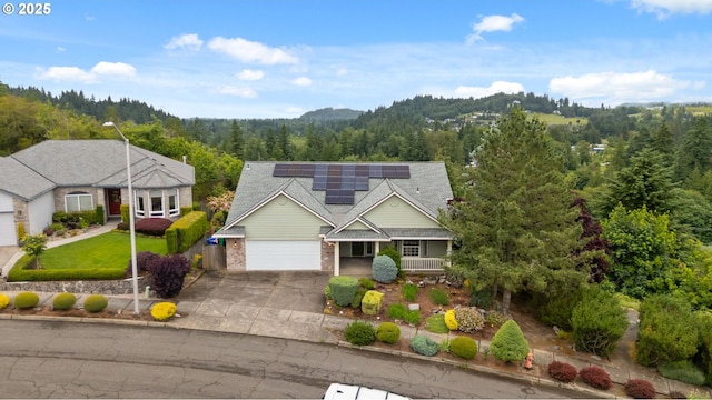 15745 SE Bybee Dr, Portland, OR 97236 - traditional-style home featuring a view of trees, concrete driveway, roof mounted solar panels, a garage, and covered porch