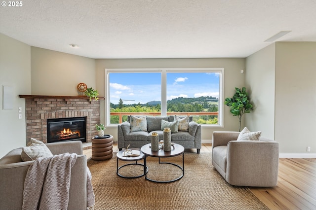15745 SE Bybee Dr, Portland, OR 97236 - living room featuring wood finished floors, a fireplace, baseboards, and a textured ceiling