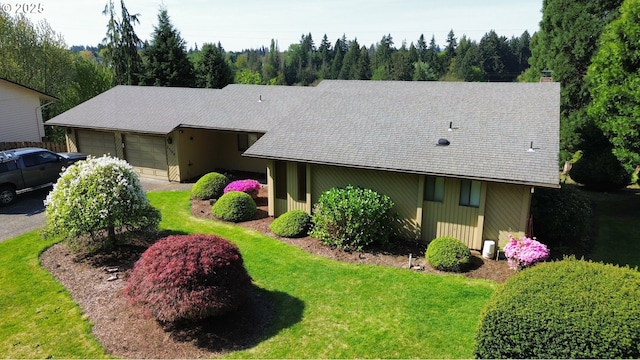 view of front of property featuring a chimney, a garage, and a front yard