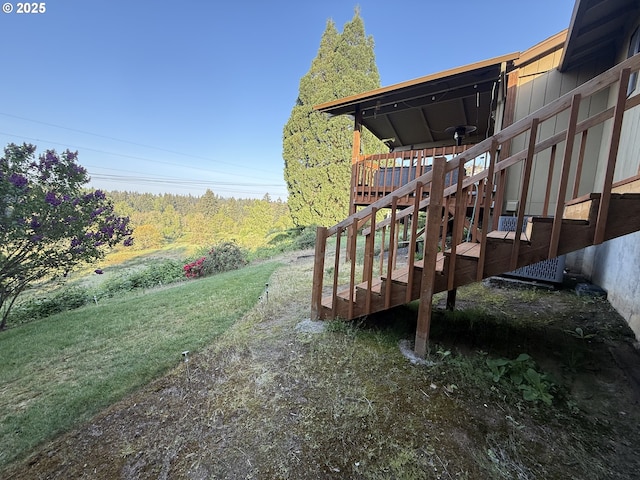 view of green lawn with stairway and a deck