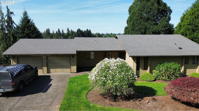 ranch-style home with a garage, a shingled roof, and asphalt driveway