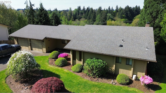aerial view of property and surrounding area featuring a heavily wooded area