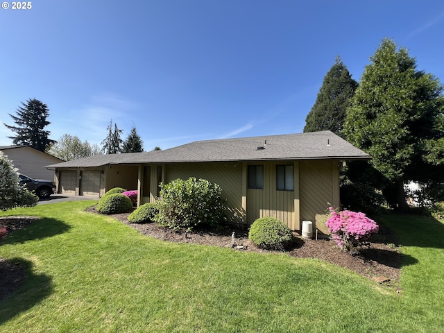 view of property exterior with an attached garage, a lawn, and driveway