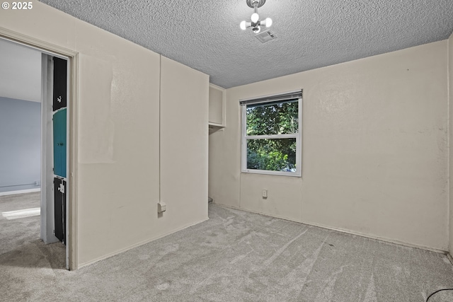 unfurnished bedroom featuring light colored carpet and a textured ceiling