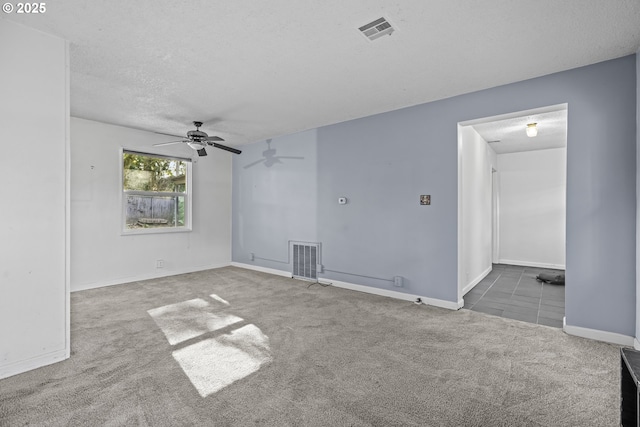 carpeted spare room featuring ceiling fan and a textured ceiling