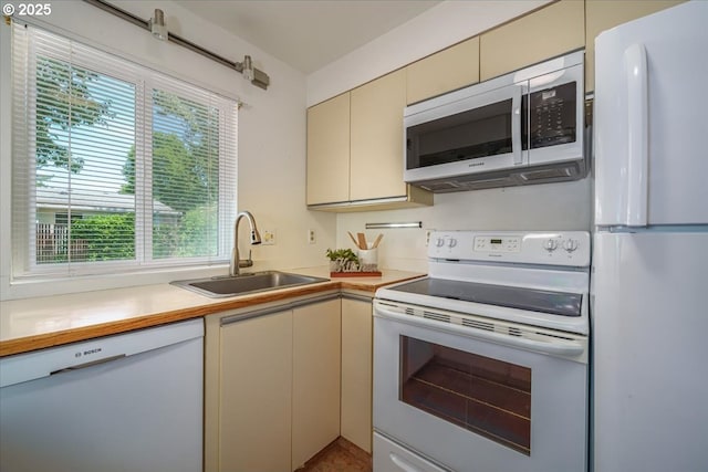 12960 SW 5th St, Beaverton, OR 97005 - kitchen featuring white appliances, cream cabinets, and healthy amount of natural light
