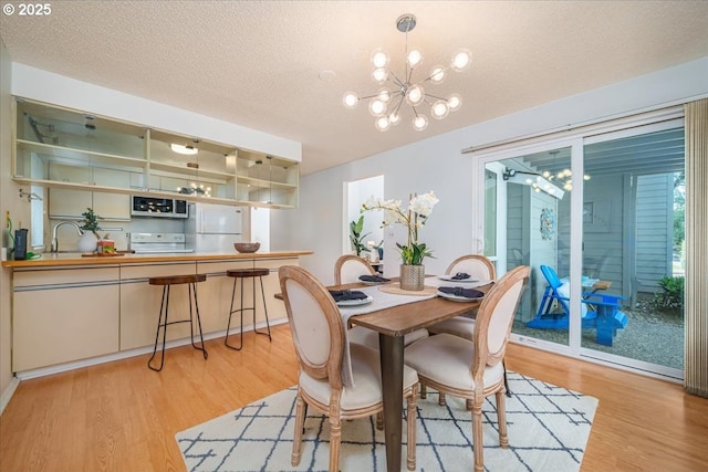 12960 SW 5th St, Beaverton, OR 97005 - dining space with a chandelier, light wood-style floors, and a textured ceiling