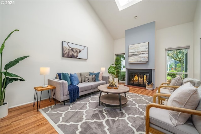 12960 SW 5th St, Beaverton, OR 97005 - living area featuring high vaulted ceiling, a skylight, wood finished floors, and a glass covered fireplace