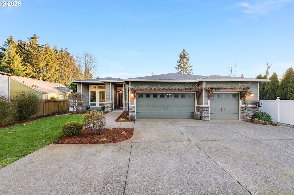 ranch-style home with a garage and a front lawn