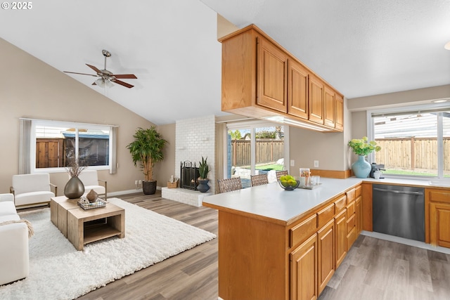 kitchen featuring ceiling fan, open floor plan, dishwasher, light countertops, and lofted ceiling