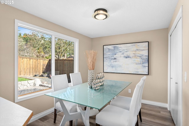 dining space featuring wood finished floors and baseboards