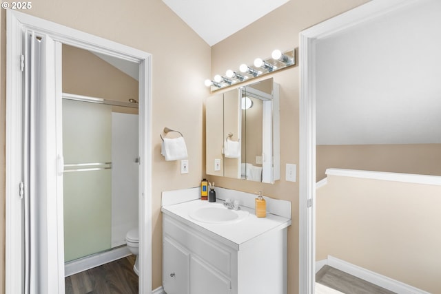 full bathroom with toilet, vaulted ceiling, a stall shower, wood finished floors, and vanity