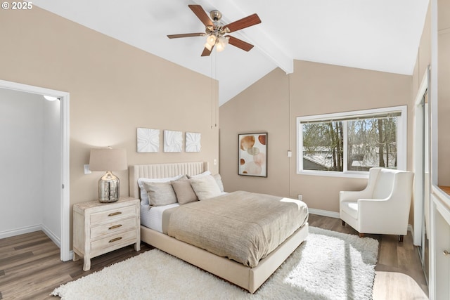 bedroom featuring a ceiling fan, lofted ceiling with beams, wood finished floors, and baseboards