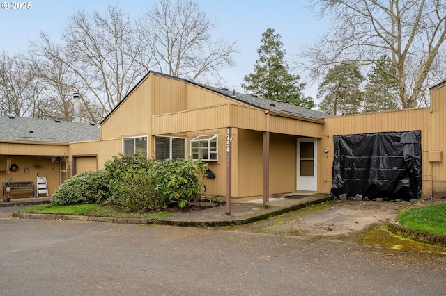 view of property exterior with a shingled roof