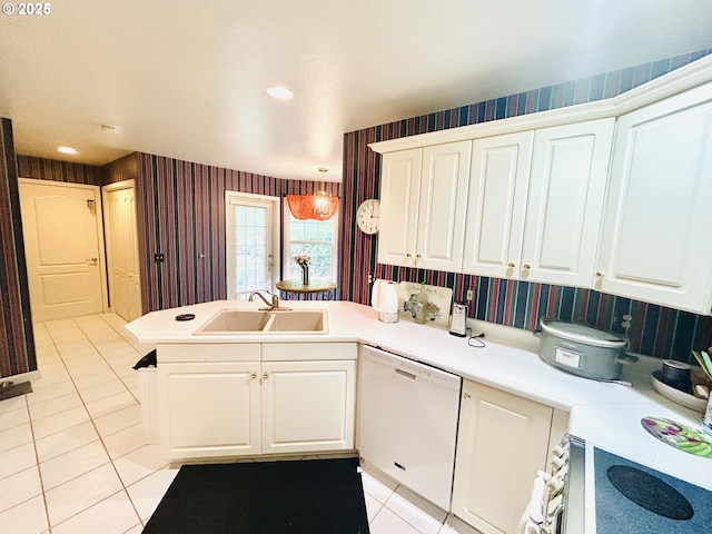 kitchen with light tile patterned floors, sink, white dishwasher, white cabinets, and kitchen peninsula