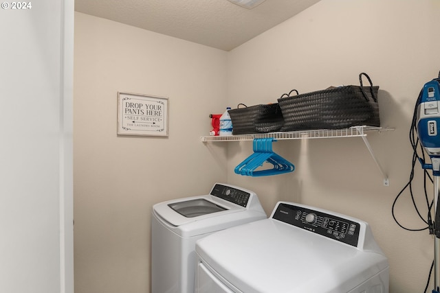 laundry room featuring washing machine and dryer and a textured ceiling