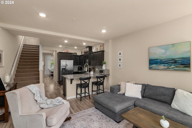 living room with light hardwood / wood-style floors and sink